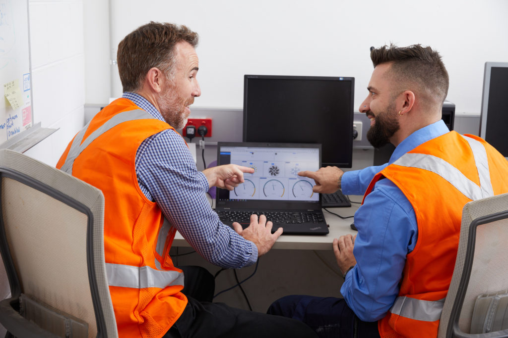 Two technicians analysing data